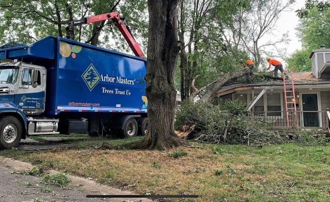 The Arbor Masters team removing a storm damaged tree from a home in Cedar Rapids, IA.