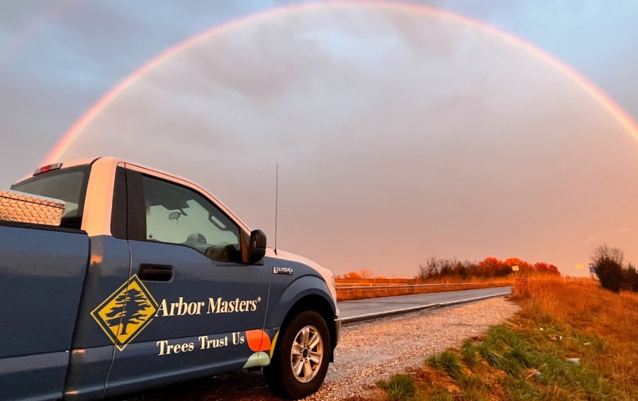 Arbor Masters tree service truck after summer storm with rainbow overhead in the sky.