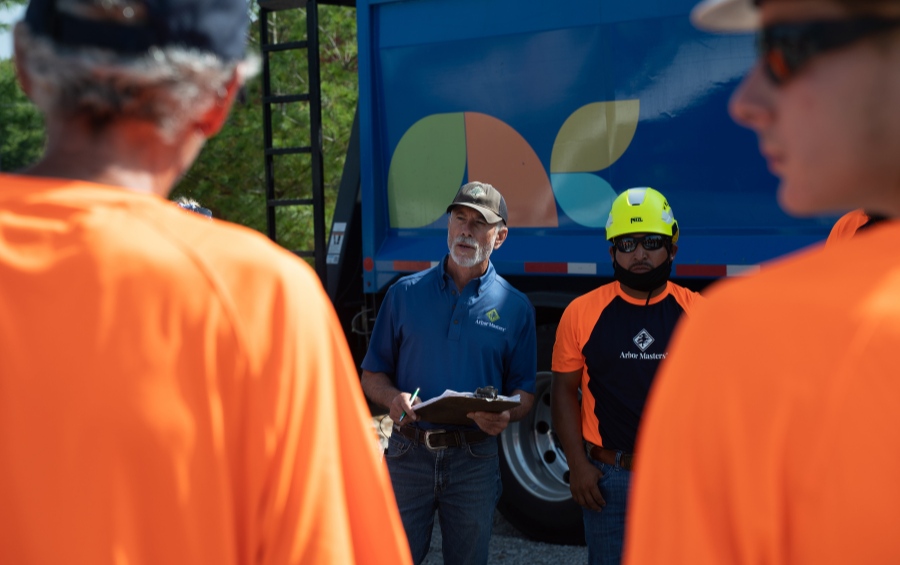 Arbor Masters ISA Certified Arborist conducting safety briefing with tree care crew before winter oak pruning project in the Quad Cities.