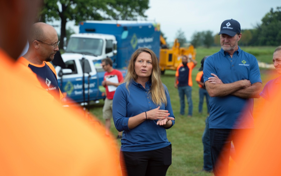Arbor Masters team meeting on job site discussing tree care safety protocols with professional equipment in Quad Cities.