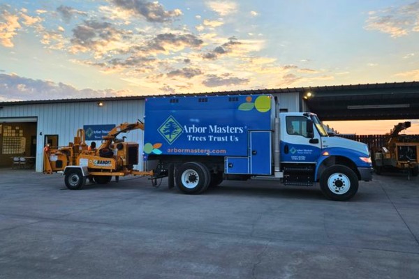 Arbor Masters chipper truck at sunset — professional tree care company serving Arlington, TX