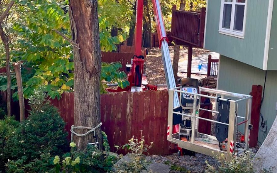 The team at Arbor Masters using a spider lift to assist in removing a tree in a tight space in Dallas, TX.