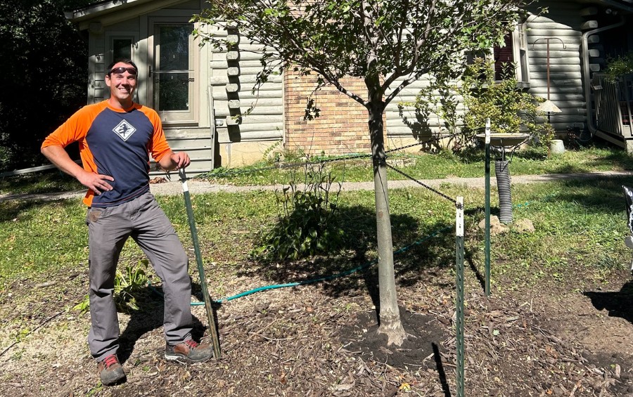 An Arbor Masters arborist poses next to a tree he planted in Colleyville, TX.