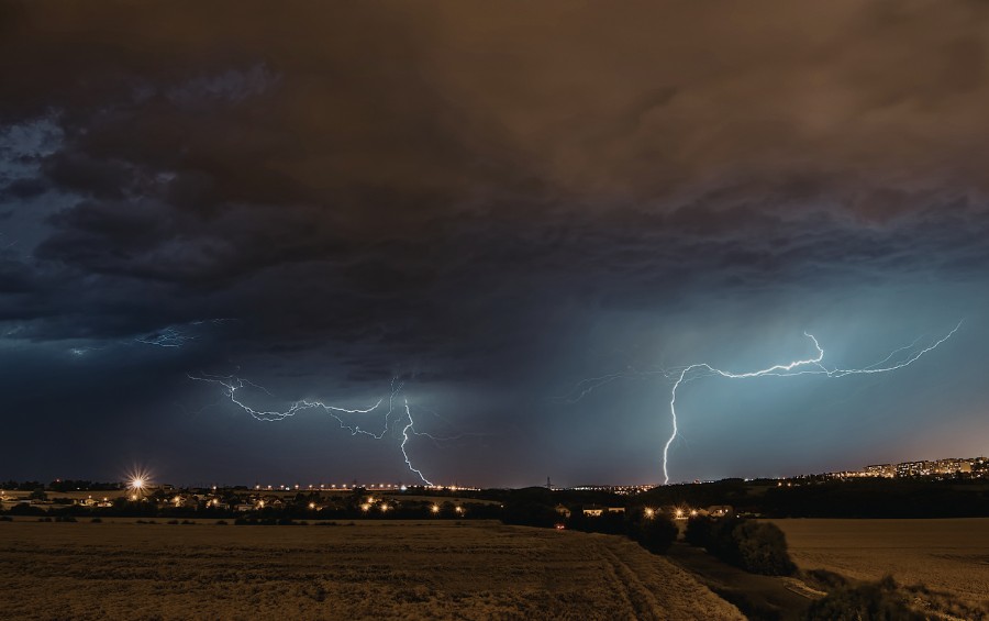 Lightning strikes illuminate the Fort Worth city skyline during an intense thunderstorm with dark clouds overhead.