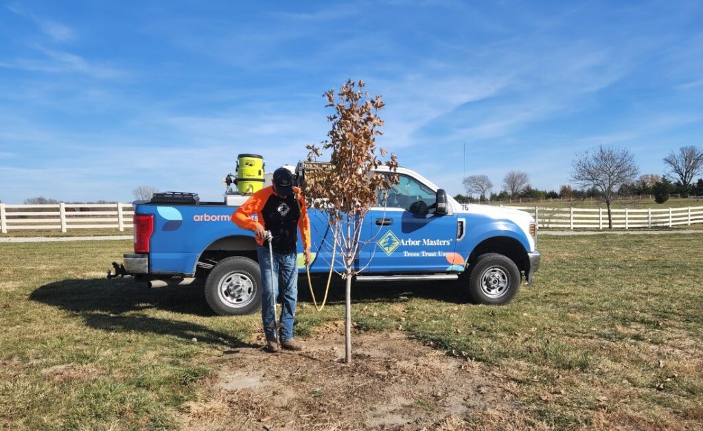 An arborist from Arbor Masters performs fertilization in Tulsa, OK.