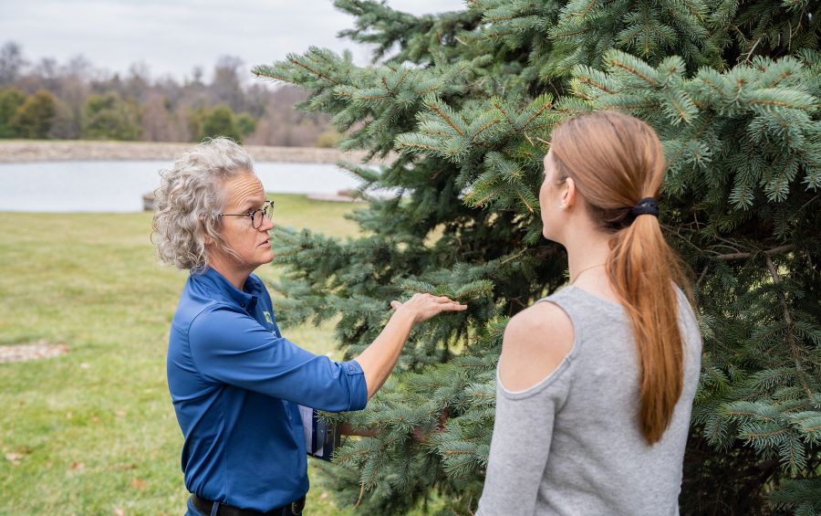 An arborist from Arbor Masters discussing tree removal with a customer in Yukon, OK.