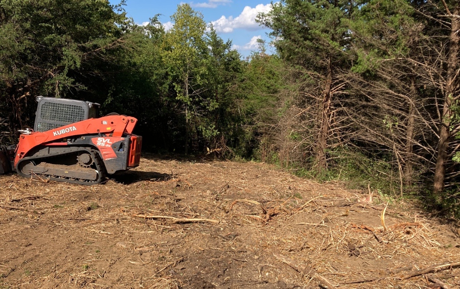 A cleared lot in Oklahoma City showing removed vegetation and preserved trees on the perimeter to meet local preservation requirements.