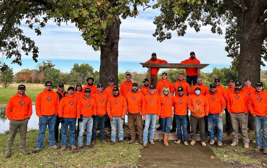Arbor Masters certified arborist team gathering under mature oak trees in Johnson County demonstrating professional tree care expertise.