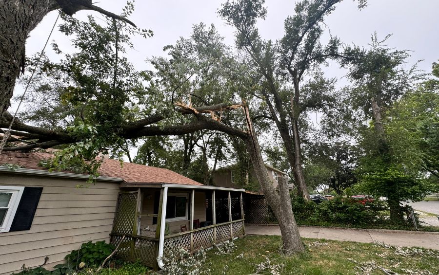 A storm-damaged tree that has fallen on a house in Bixby, OK.