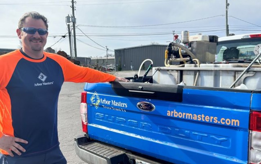 Arbor Masters plant health care technician Scott standing beside a specialized treatment truck.