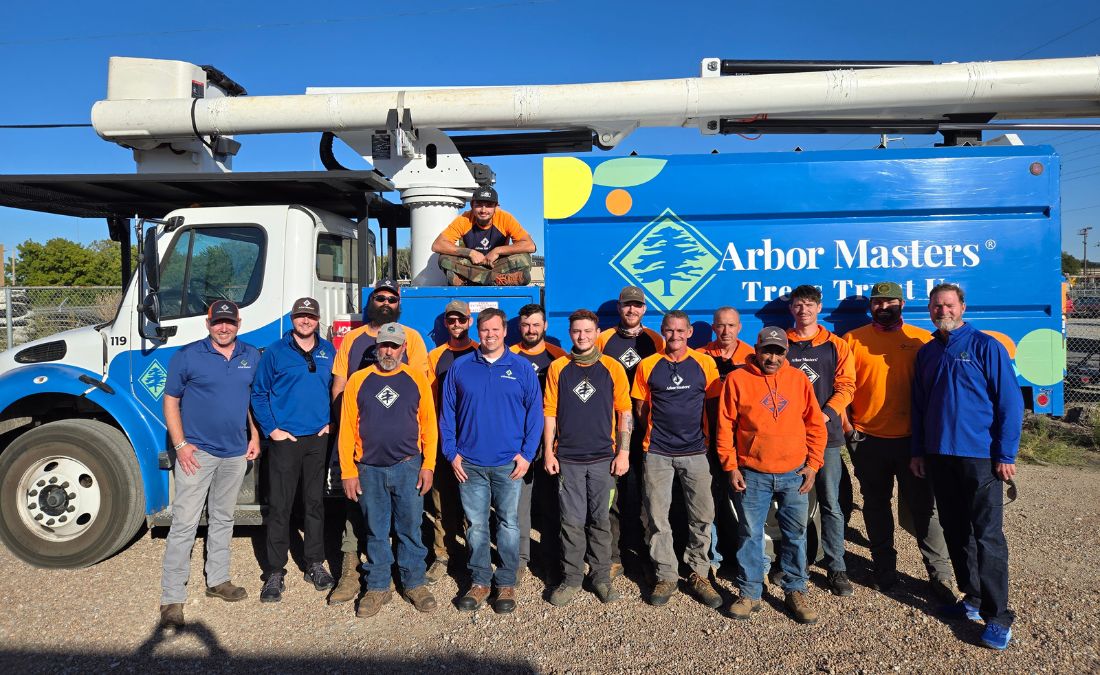 The Arbor Masters Wichita team posing in front of their bucket truck.