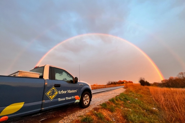 Arbor Masters truck on a summer during a sunset with a rainbox view in IA.