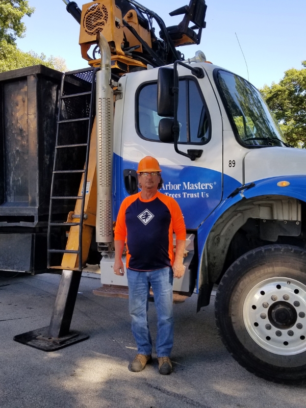 A tree crew of Arbor Masters with a truck background on a summer day in Kansas City, MO.