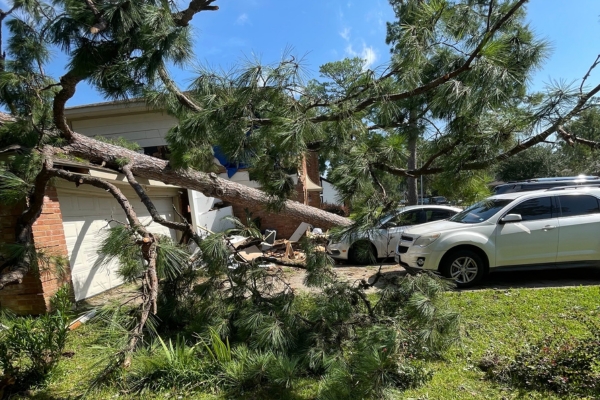 A fallen tree on the roof of a garage that needs an emergency removal on a residence in Kansas City.